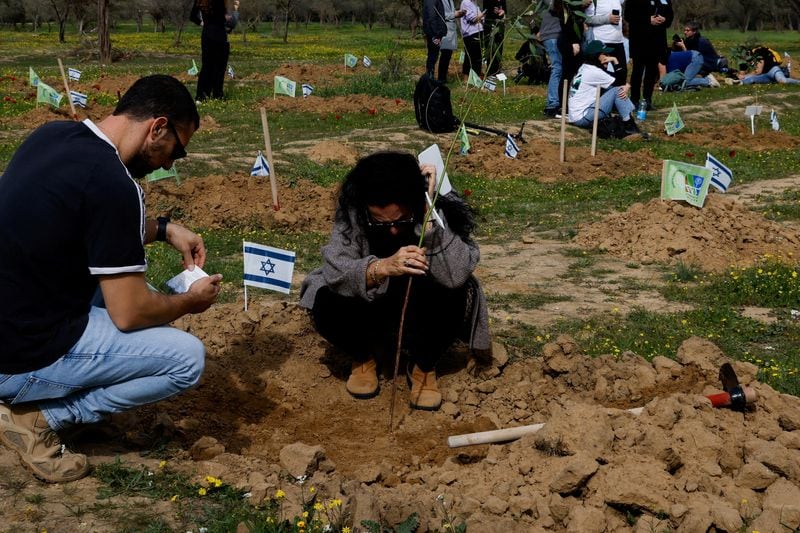 Familiares y cercanos plantan árboles en el lugar donde se realizó el festival NOVA en memoria de las personas que murieron y fueron secuestradas durante el ataque de Hamas (REUTERS/Tyrone Siu)