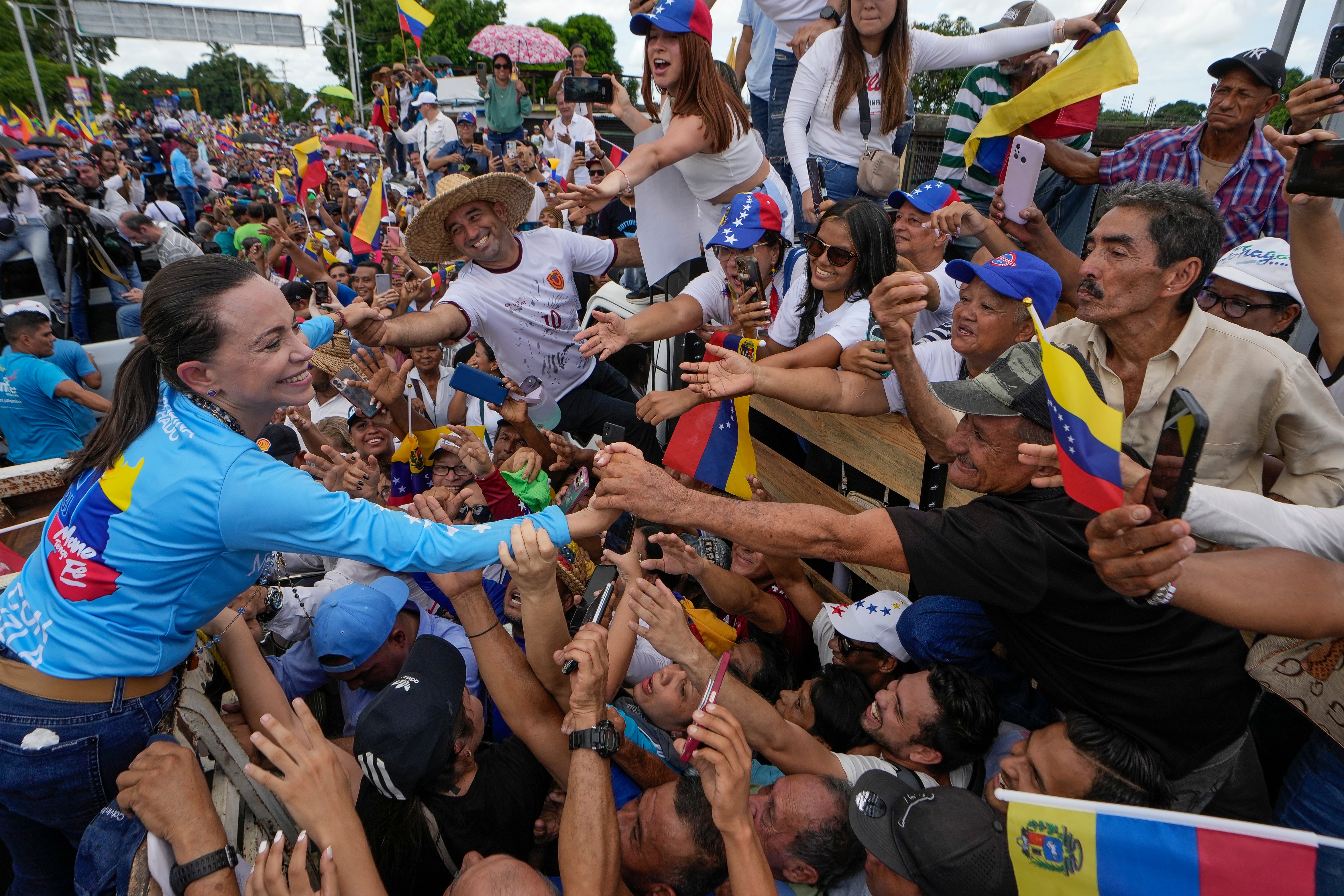 La líder opositora María Corina Machado saluda a sus seguidores en un acto de campaña por la candidatura presidencial de Edmundo González en Maturín, Venezuela, Foto. AP/Matías Delacroix