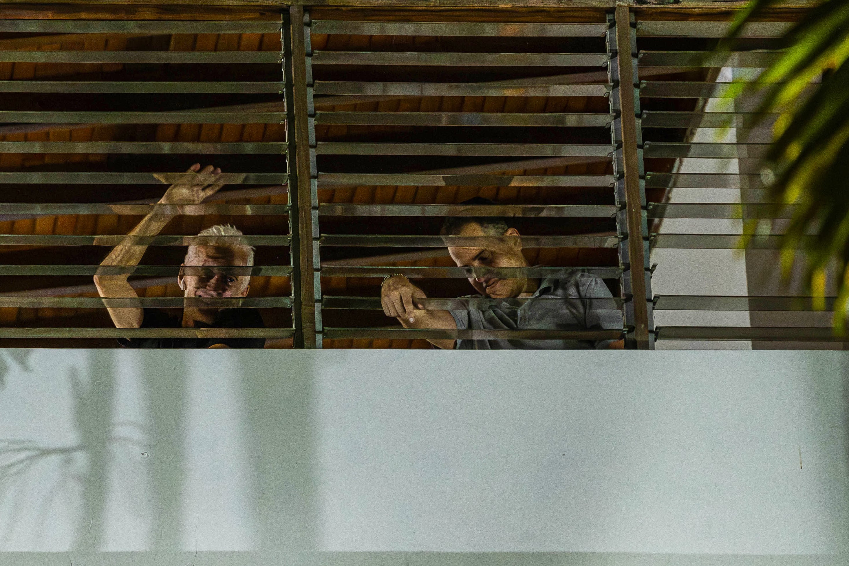 Dos de los seis opositores venezolanos que se encuentran refugiados en la residencia oficial de la embajada de Argentina en Caracas, saludan desde una ventana. Foto: EFE/ Henry Chirinos 