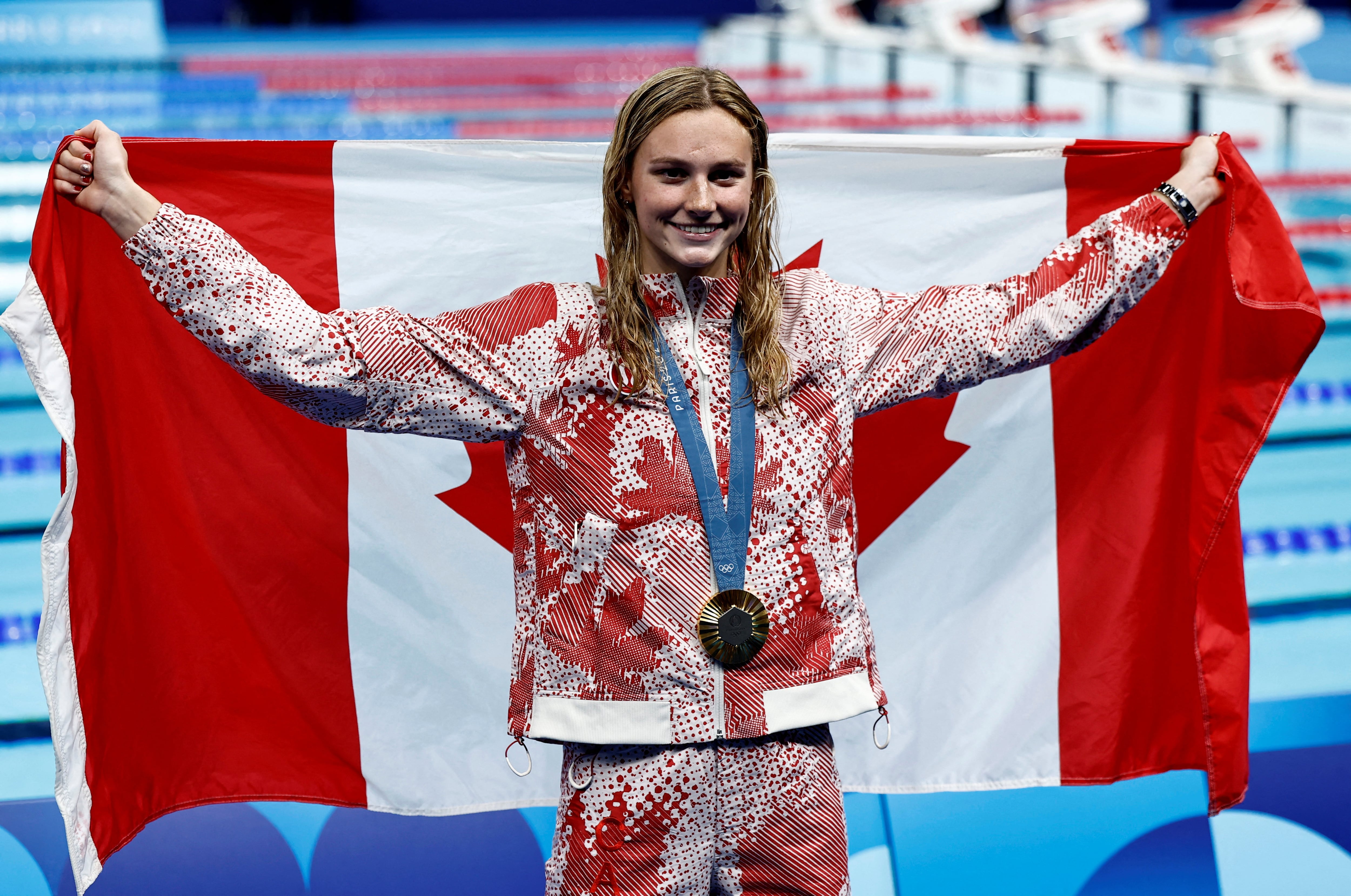 La canadiense Summer McIntosh celebra en el podio tras ganar la medalla de oro en la final de los 200 metros combinados en París 2024 (REUTERS/Clodagh Kilcoyne)