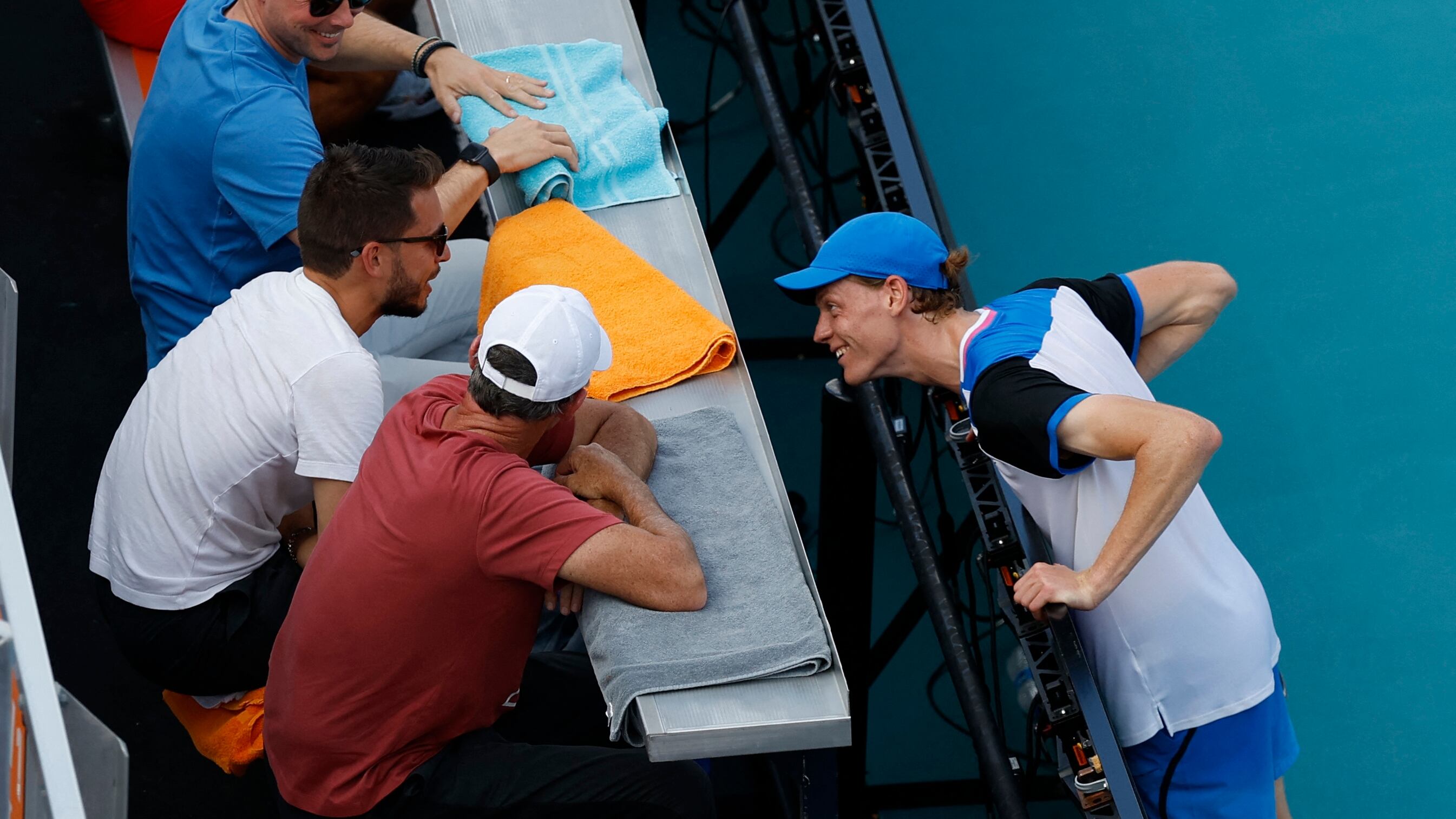 Mar 26, 2024; Miami Gardens, FL, USA; Jannik Sinner (ITA) (R) jokes with a member of his team after accidentally striking him with an errant shot against Christopher O'Connell (AUS) (not pictured) on day nine of the Miami Open at Hard Rock Stadium. Mandatory Credit: Geoff Burke-USA TODAY Sports