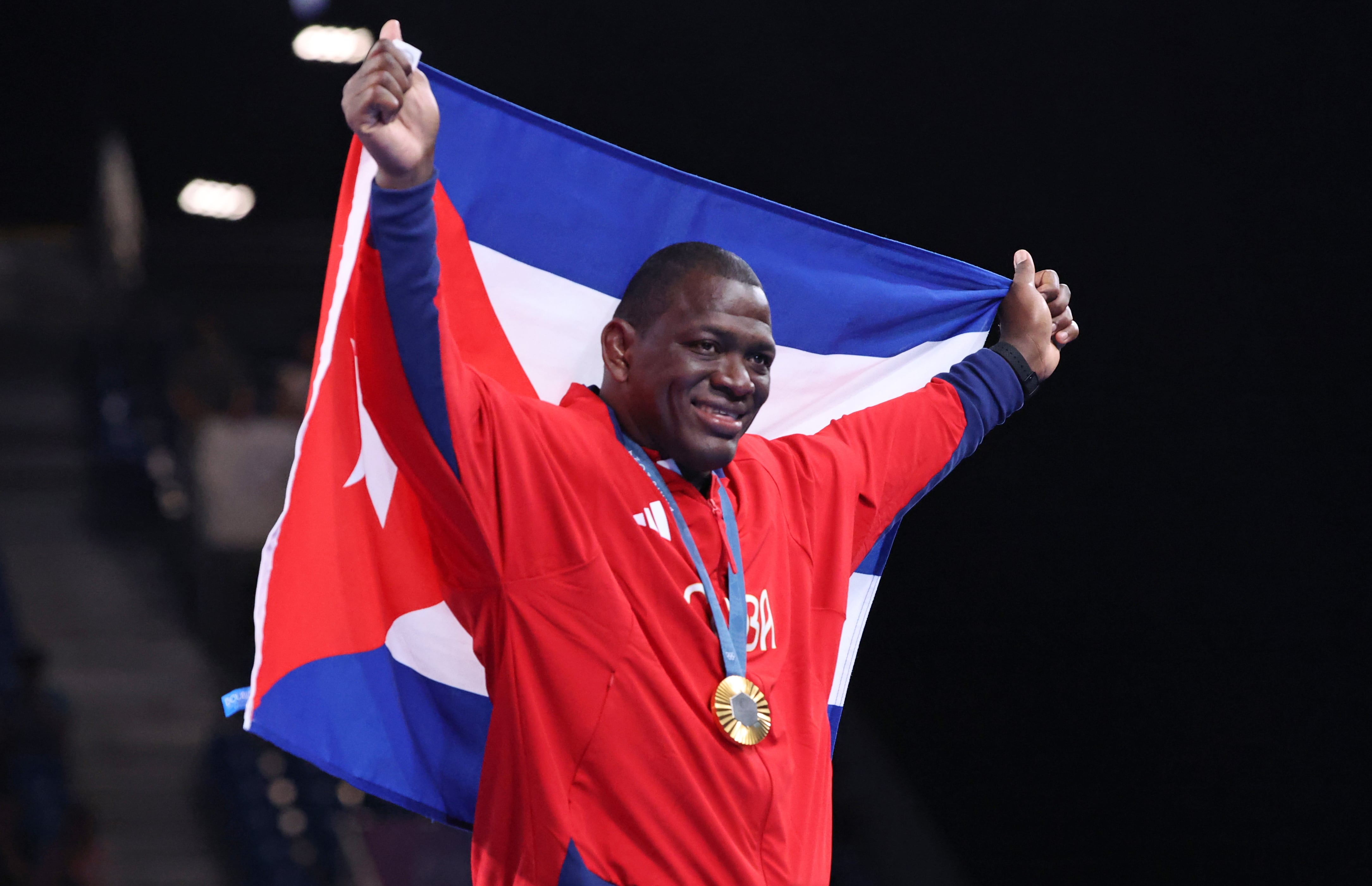 El medallista olímpico cubano Mijain Lopez celebra con la bandera de su país la medalla de oro obtenida en París 2024 (EFE/EPA/YAHYA ARHAB) 