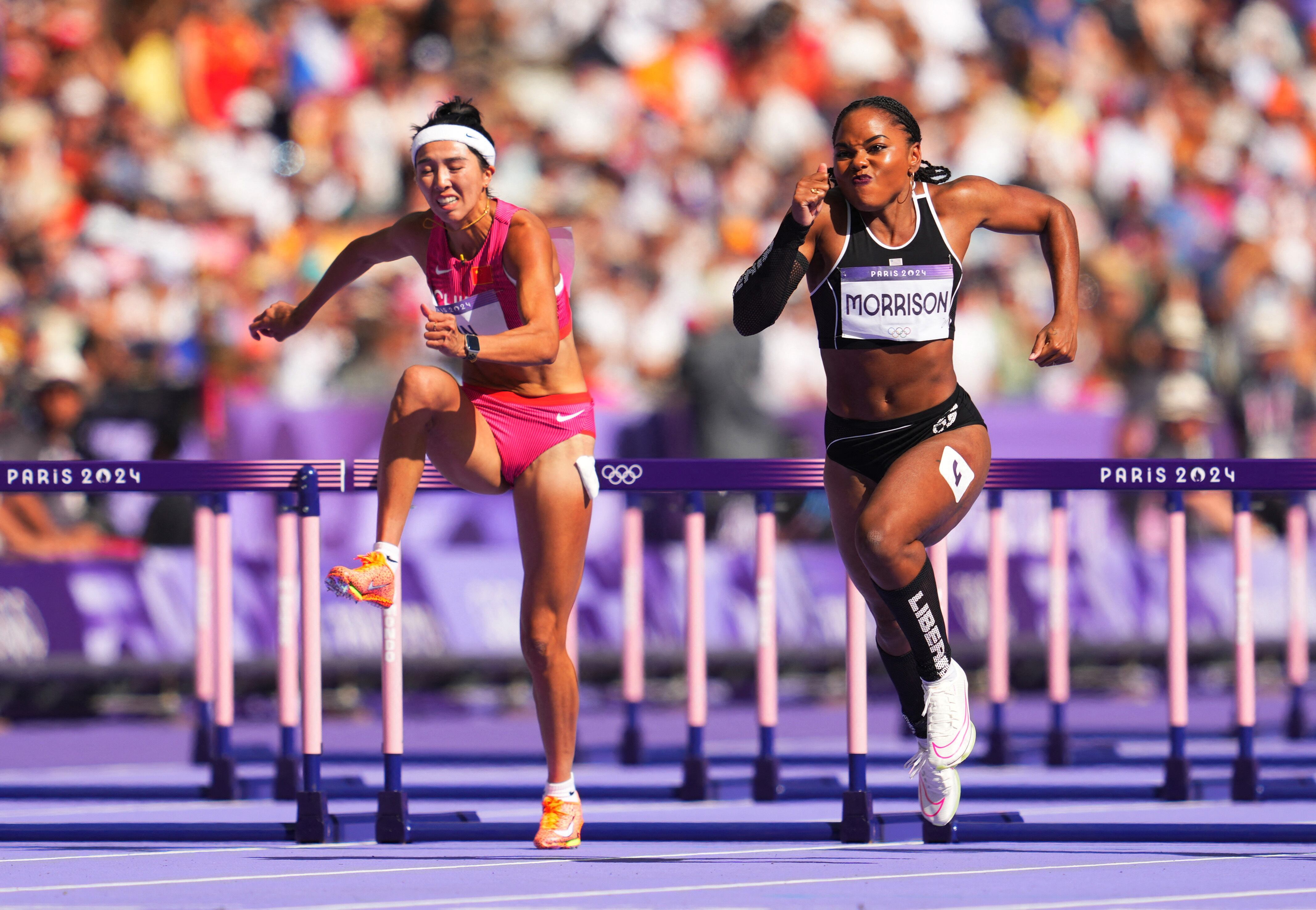 Juegos Olímpicos París 2024 - Atletismo - Repechaje de los 100 metros vallas femeninos - Stade de France, Saint-Denis, Francia - 08 de agosto de 2024. Ebony Morrison de Liberia y Yuwei Lin de China en acción durante la serie 2. REUTERS/Aleksandra Szmigiel