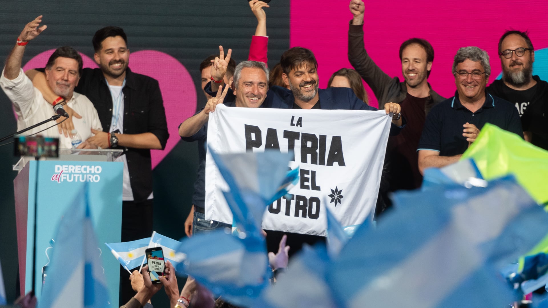 Carlos Bianco y Andrés Larroque con bandera donde se lee La Patria es el otro