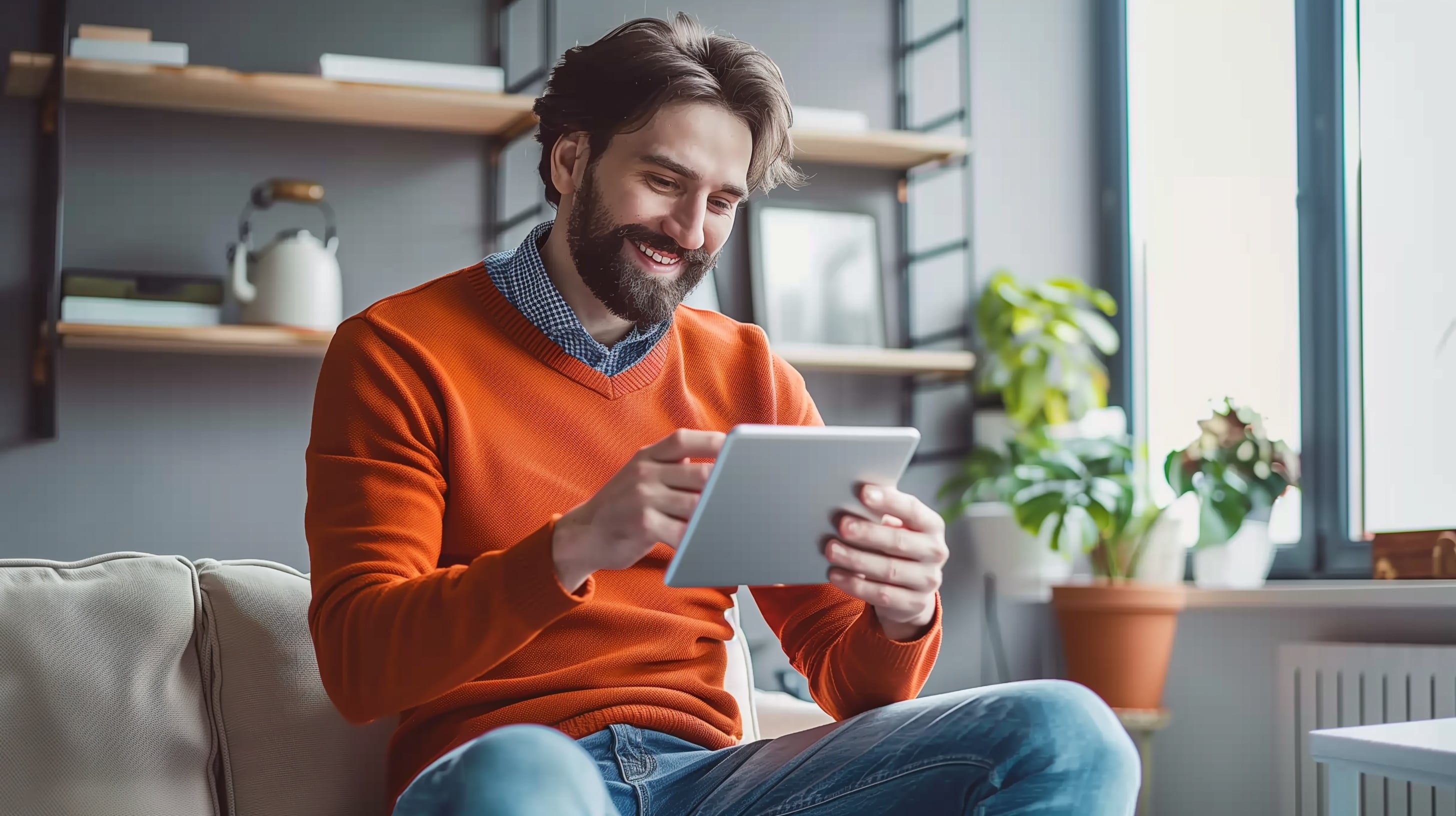 Trabajador remoto, hombre sonriente, entorno de trabajo en casa, uso de tablet, bienestar laboral, tecnología en home office - (Imagen Ilustrativa Infobae)