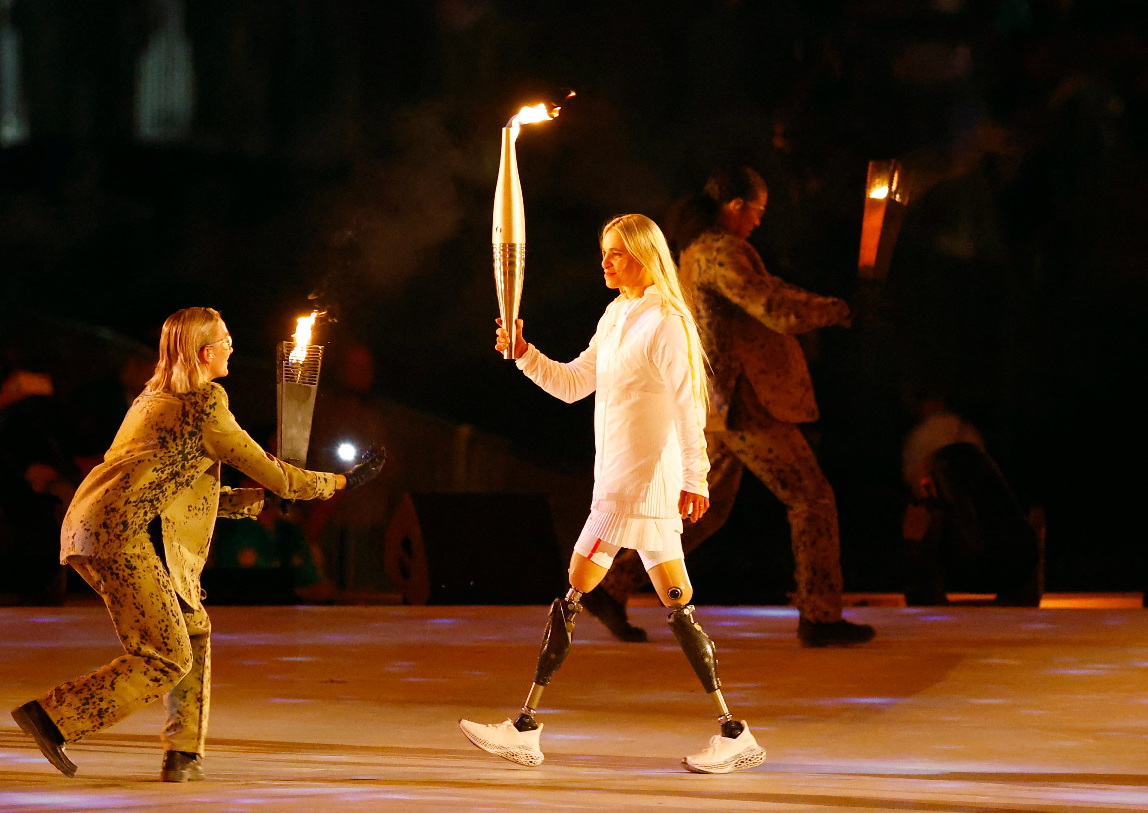 Oksana Masters llevando la antorcha olímpica en la ceremonia de los Juegos Paralímpicos. París 2024 es el séptimo evento paralímpico para Oksana, que competirá en ciclismo.