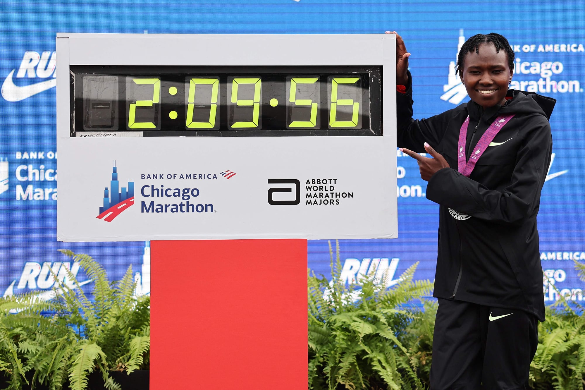 Ruth Chepngetich posa con el reloj que muestra su nuevo récord mundial, en el Grant Park de Chicago (Photo by Michael Reaves / GETTY IMAGES NORTH AMERICA / Getty Images via AFP)