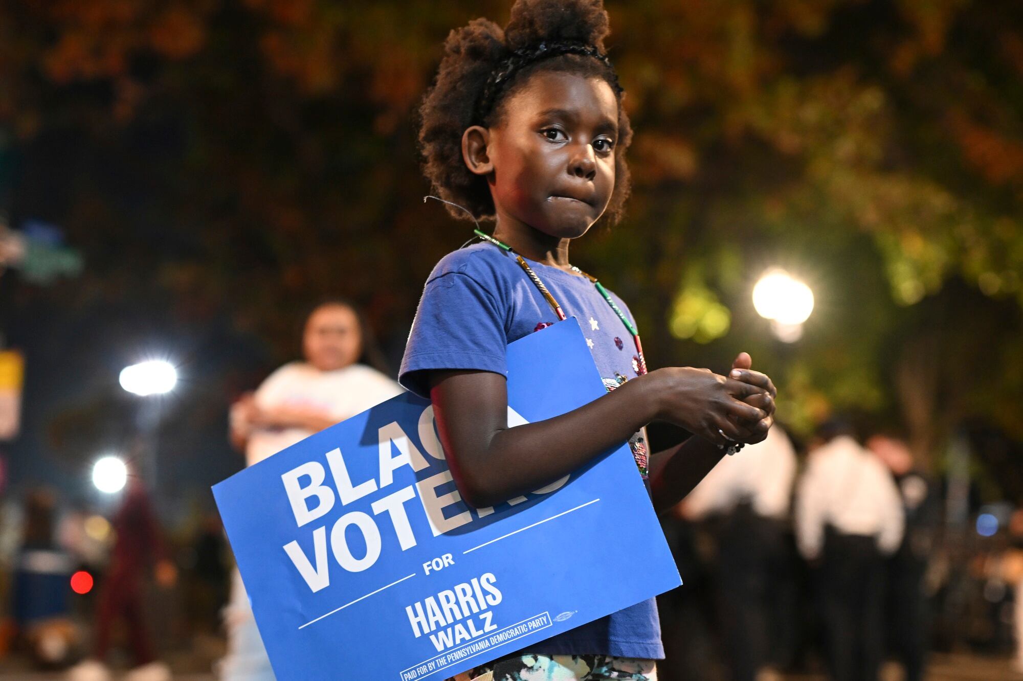 Una joven sostiene un cartel de «Votantes negros por Harris-Walz» en el exterior de la fiesta de la noche electoral de la candidata demócrata a la vicepresidencia Kamala Harris en la Universidad Howard, el martes 5 de noviembre de 2024, en Washington.